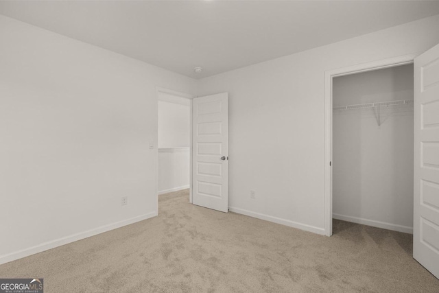 unfurnished bedroom with carpet floors, a closet, and baseboards