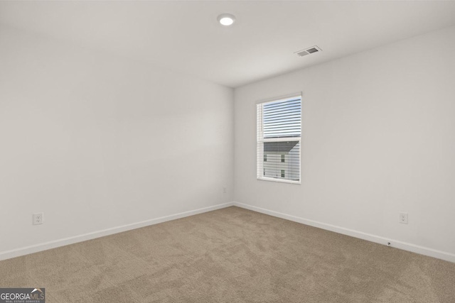 carpeted empty room with visible vents and baseboards