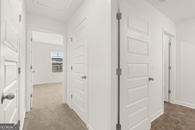 hall featuring carpet and baseboards