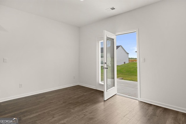 interior space with dark wood finished floors, visible vents, and baseboards