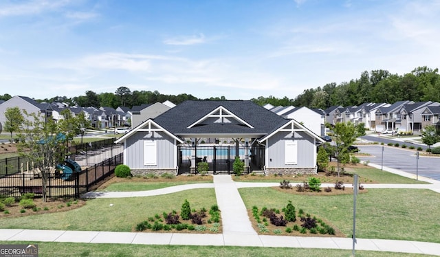 view of front of house featuring board and batten siding, a residential view, fence, and a front lawn