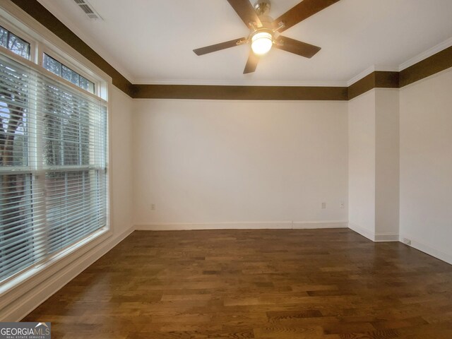 empty room with ornamental molding, wood finished floors, and visible vents