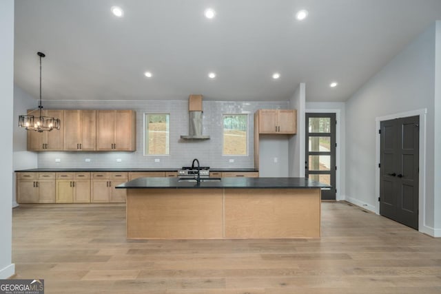544 Lemmon Ln, Ellijay, GA 30540 - kitchen with a kitchen island with sink, wall chimney range hood, backsplash, light wood finished floors, and dark countertops