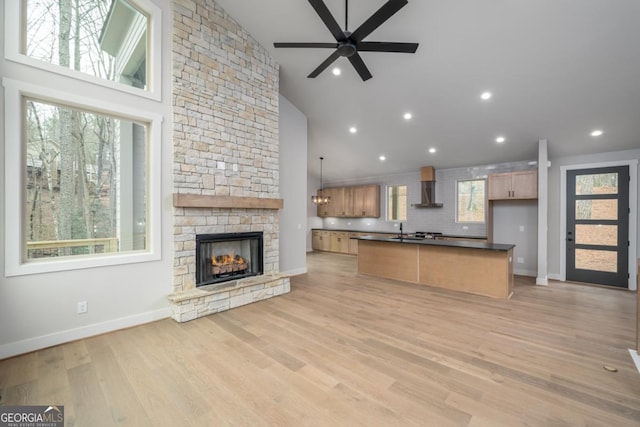 544 Lemmon Ln, Ellijay, GA 30540 - kitchen with a fireplace, open floor plan, wall chimney range hood, light wood-type flooring, and dark countertops