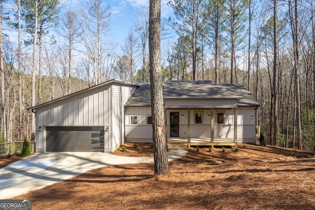 544 Lemmon Ln, Ellijay, GA 30540 - view of front of house featuring a garage, covered porch, driveway, a forest view, and board and batten siding