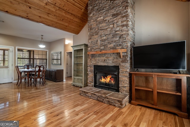 unfurnished living room featuring high vaulted ceiling, a fireplace, wood finished floors, and wooden ceiling