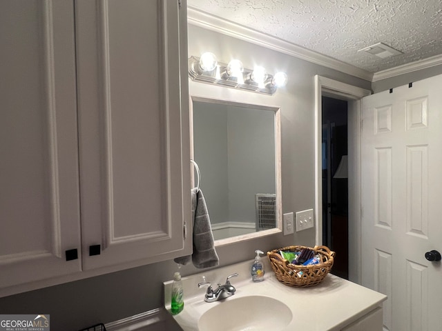 bathroom featuring crown molding, visible vents, a textured ceiling, and vanity