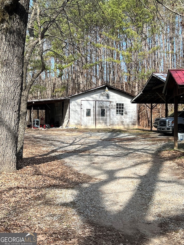 view of outdoor structure with a carport and driveway