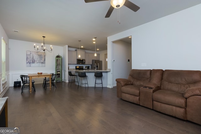 5620 Berney Cir, Powder Springs, GA 30127 - living area featuring dark wood-style floors, recessed lighting, wainscoting, and ceiling fan with notable chandelier