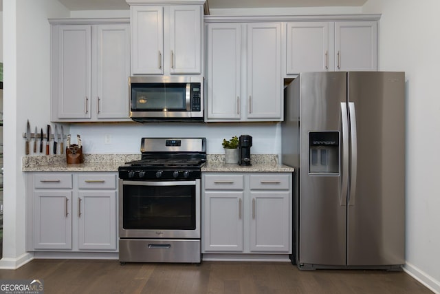5620 Berney Cir, Powder Springs, GA 30127 - kitchen with light stone countertops, dark wood-style floors, baseboards, and stainless steel appliances