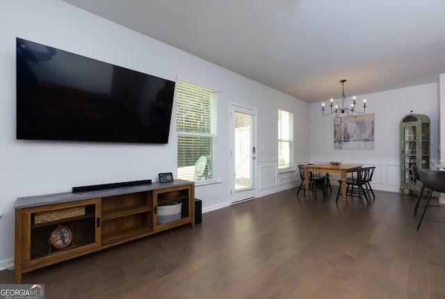 5620 Berney Cir, Powder Springs, GA 30127 - living room with a chandelier, dark wood-style flooring, wainscoting, and a decorative wall
