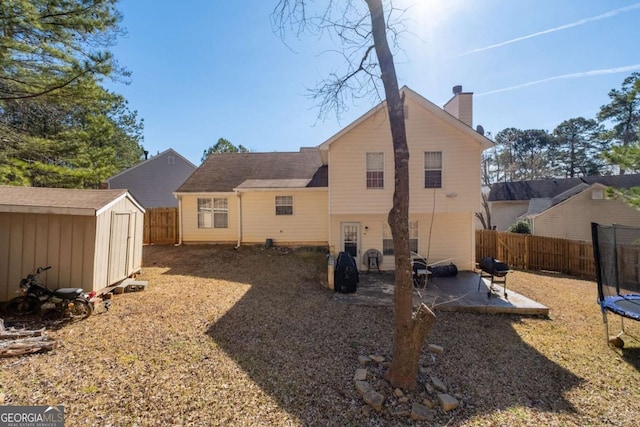 2860 River Close Dr, Decatur, GA 30034 - rear view of property with a trampoline, a patio, a storage shed, a fenced backyard, and a chimney