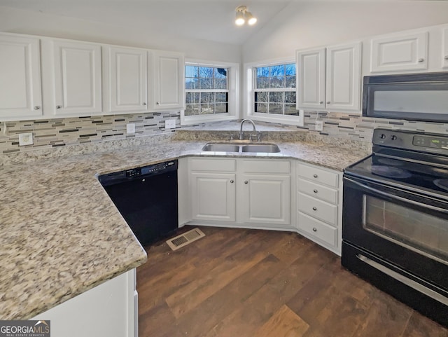 kitchen with visible vents, backsplash, vaulted ceiling, a sink, and black appliances