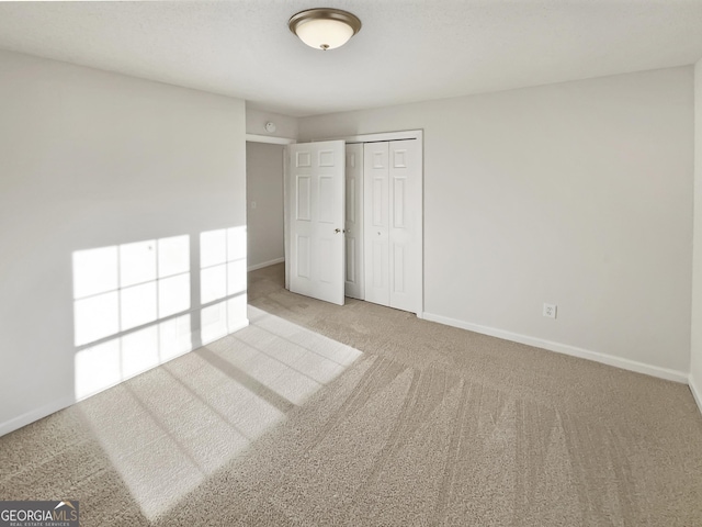 unfurnished bedroom featuring a closet, carpet flooring, and baseboards