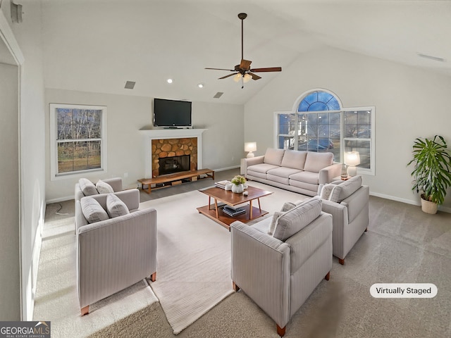 living area with lofted ceiling, light colored carpet, a ceiling fan, a stone fireplace, and baseboards