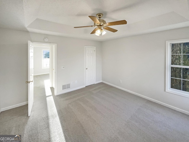 unfurnished bedroom featuring baseboards, visible vents, ceiling fan, and carpet flooring