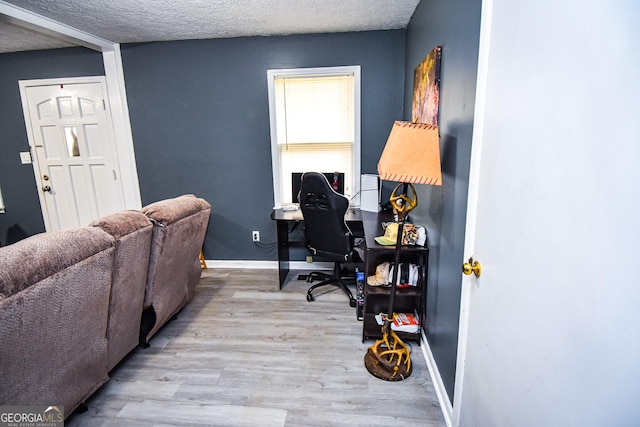 office space featuring a textured ceiling, baseboards, and wood finished floors