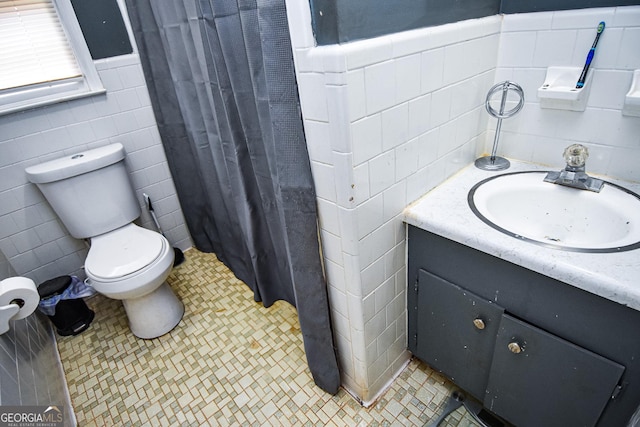 full bathroom with tile patterned flooring, toilet, a shower with shower curtain, vanity, and tile walls