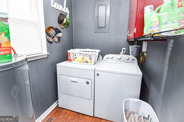 laundry area featuring laundry area, electric panel, light wood-style floors, and washing machine and clothes dryer