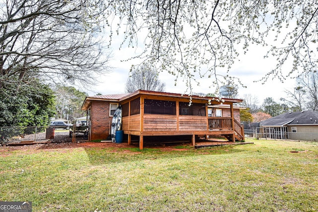 rear view of property with a lawn, a sunroom, metal roof, fence, and brick siding