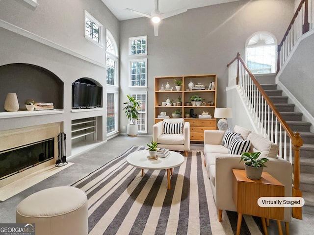 interior space with stairway, a high end fireplace, plenty of natural light, and a towering ceiling