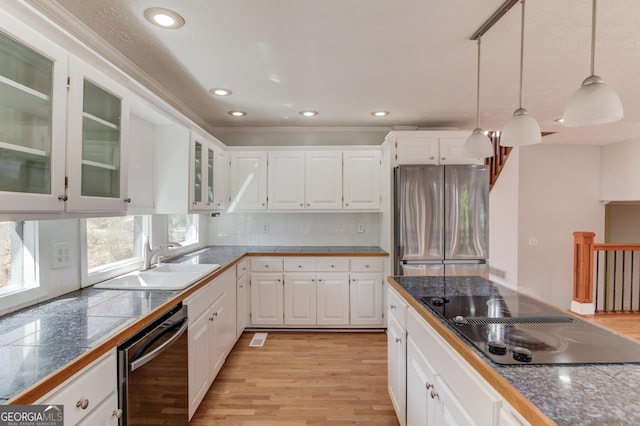 kitchen with dishwashing machine, glass insert cabinets, freestanding refrigerator, black electric cooktop, and a sink