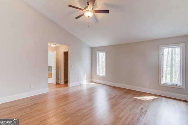 unfurnished room featuring light wood-type flooring, baseboards, and vaulted ceiling