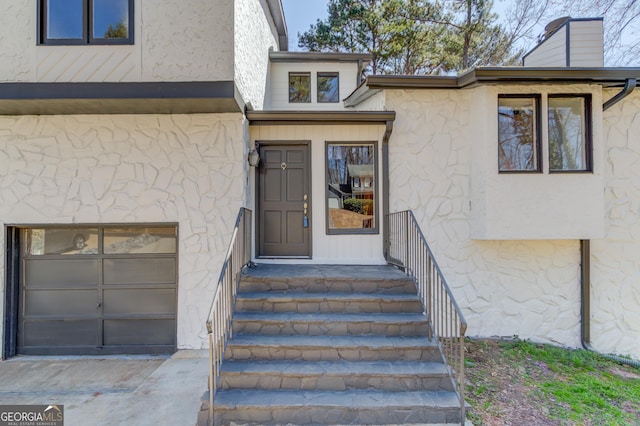 doorway to property featuring a garage, stone siding, a chimney, and stucco siding