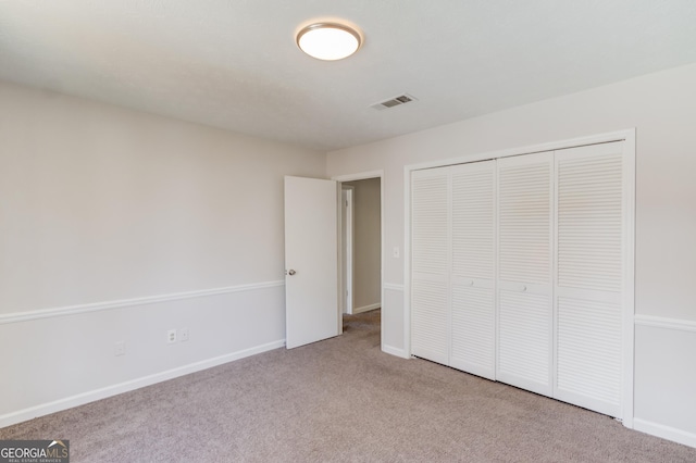 unfurnished bedroom featuring a closet, baseboards, visible vents, and carpet flooring