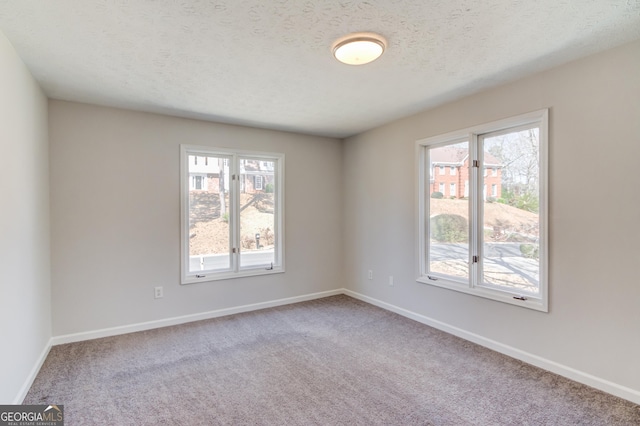 unfurnished room featuring carpet floors, baseboards, and a textured ceiling