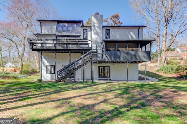 rear view of house with a sunroom, stairs, a chimney, and a deck