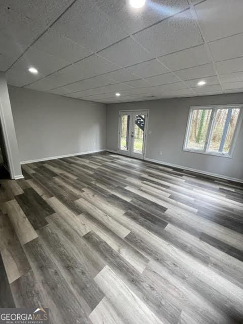 unfurnished room with baseboards, a wealth of natural light, and wood finished floors