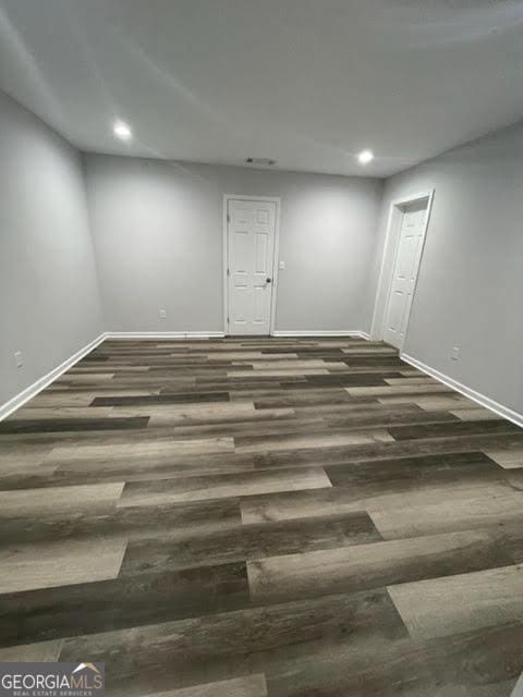 empty room featuring recessed lighting, wood finished floors, and baseboards