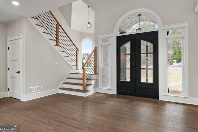 foyer entrance with french doors, visible vents, baseboards, and wood finished floors