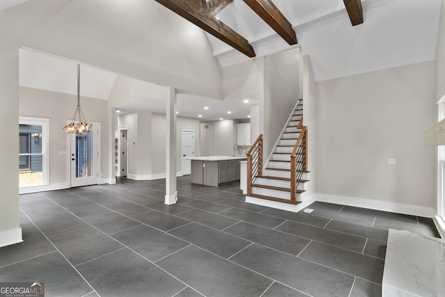 foyer entrance with a chandelier, beam ceiling, high vaulted ceiling, and stairway