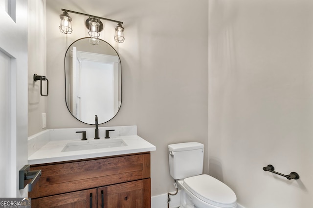 half bathroom featuring vanity and toilet