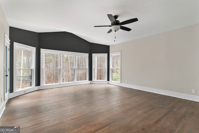 unfurnished room with a ceiling fan, dark wood-style flooring, vaulted ceiling, and baseboards