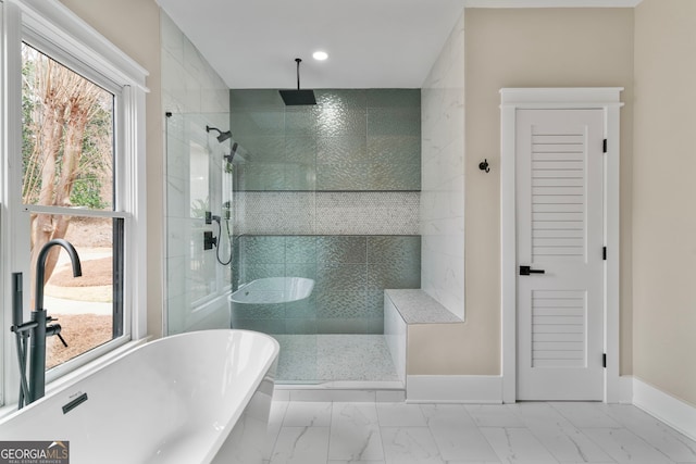 bathroom with marble finish floor, recessed lighting, a freestanding tub, baseboards, and walk in shower