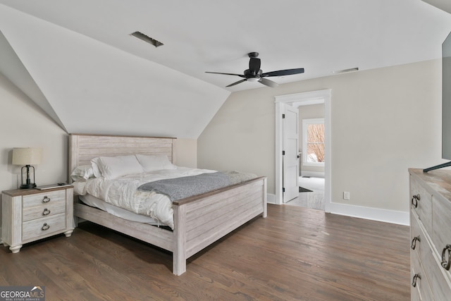 bedroom with dark wood-type flooring, visible vents, vaulted ceiling, and baseboards