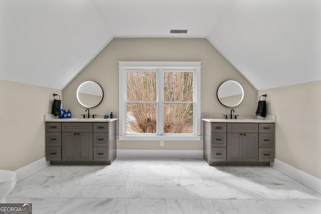 bathroom with marble finish floor, baseboards, two vanities, and a sink