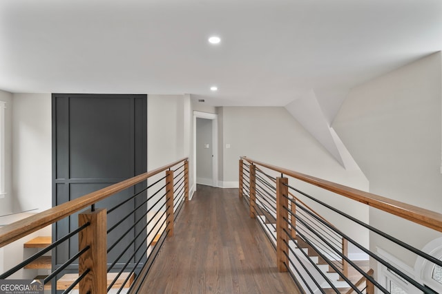 hallway featuring an upstairs landing, baseboards, wood finished floors, and recessed lighting