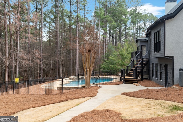 exterior space featuring stairway, a patio area, fence, and a fenced in pool