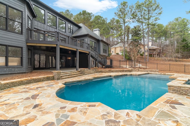 view of pool with a fenced in pool, a patio area, fence, a wooden deck, and stairs