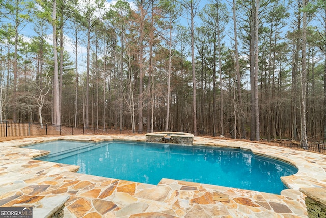 view of pool featuring a pool with connected hot tub, a patio area, and fence