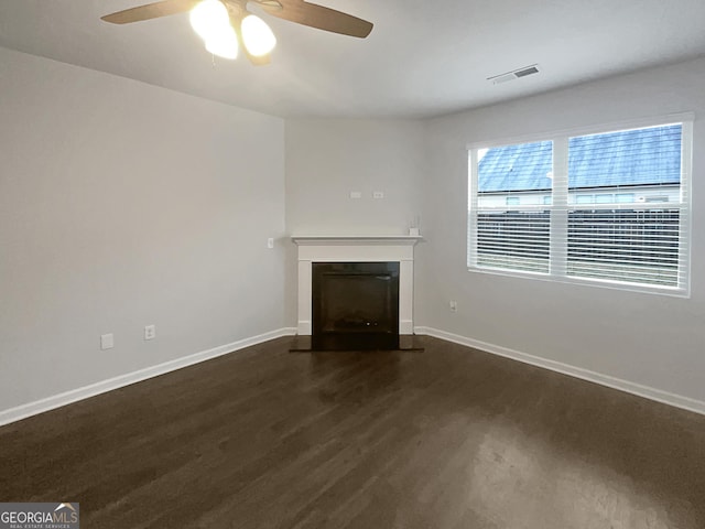 unfurnished living room featuring wood finished floors, a fireplace with flush hearth, visible vents, and baseboards