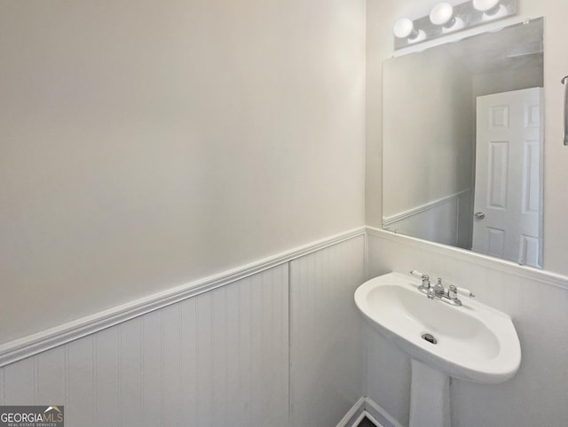 bathroom featuring a wainscoted wall and a sink
