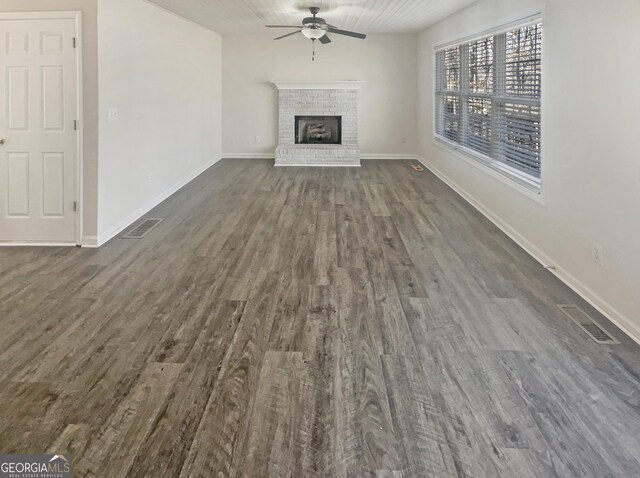 unfurnished living room featuring dark wood-style floors, a fireplace, and visible vents
