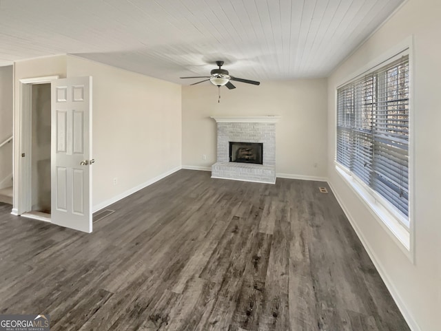 unfurnished living room featuring light wood finished floors, visible vents, a brick fireplace, ceiling fan, and baseboards