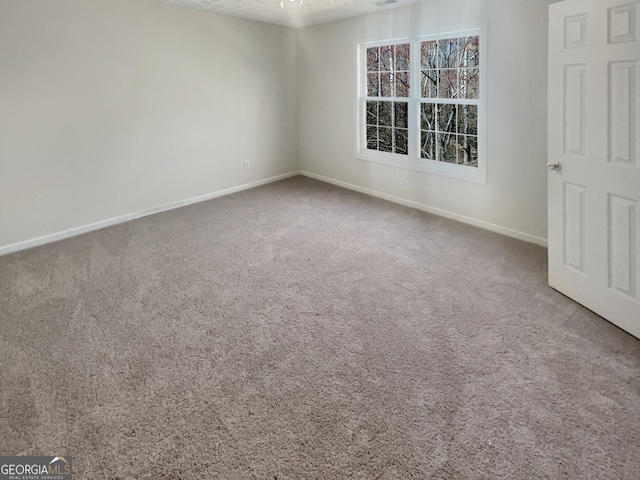 empty room featuring carpet flooring and baseboards