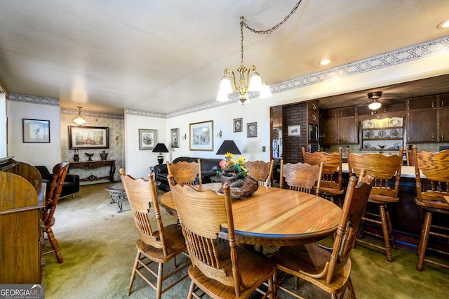 dining space featuring carpet flooring and ceiling fan with notable chandelier